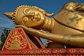 Vientiane, Laos - Pha That Luang, large gilded reclining Buddha within the temple area. 